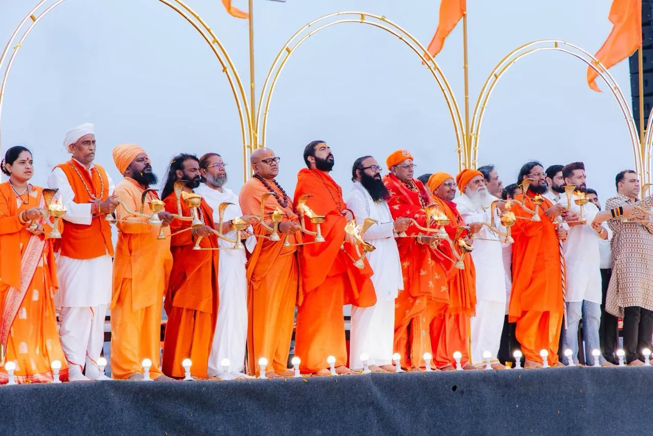 Saints and devotees offering aarti together at the spiritual festival
